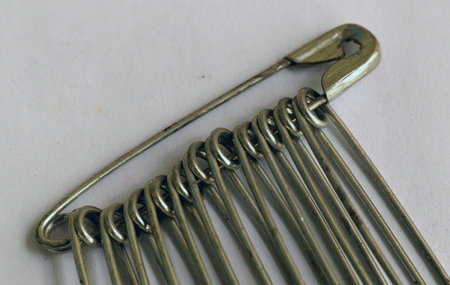 Close up of a safety pin isolated on white background with copy space