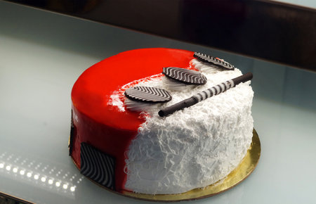 Close-up view of decorated cake in refrigerated display unit of a bakery shop