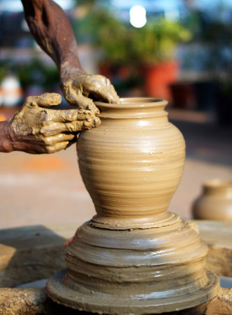 Close-up stock photo of potter making a eathen vase on the wheel in outdoorsの写真素材