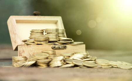 Golden money coins in a wooden box - fortune, lottery win conceptの写真素材