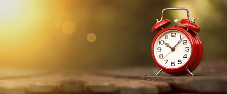 Time management concept - website banner of a vintage red alarm clock 