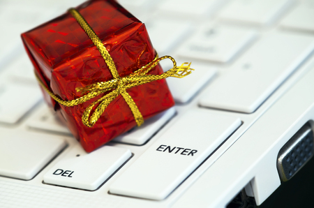 Red gift-box on a white laptop keyboardの写真素材