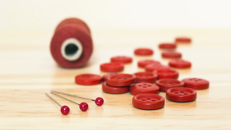 Red sewing supplies - button, pin and thread close-upの写真素材