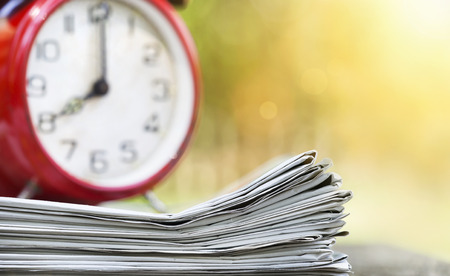 Morning news concept - Newspaper and red alarm clock with copy spaceの写真素材