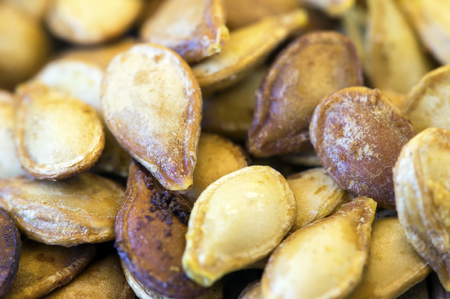 Close-up of roasted yellow pumpkin seeds, vegetarian snackの写真素材