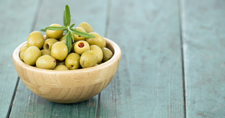 Web banner of green olives on wooden background with copy spaceの写真素材