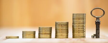 Web banner of financial solution, planning concept - gold money coins stacks and a key with blank,...