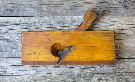 Vintage wood plane on a wooden plank background