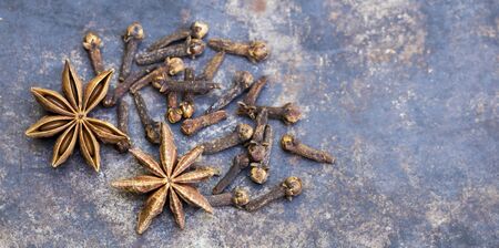Aromatic holiday spices decorations, star anise and cloves on metal background, web banner with copy spaceの写真素材