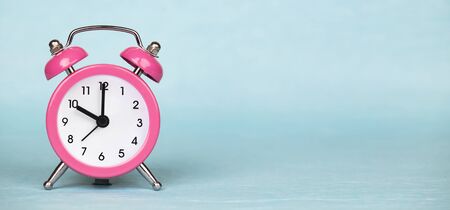 Save time, daylight saving concept, pink alarm clock on a blue background, web banner with copy...
