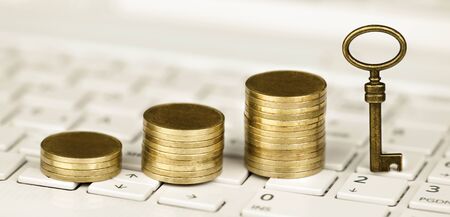 Online business success concept, gold money coins and solution key on a white laptop keyboard. Web...