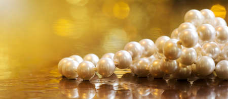 White pearls, female gift jewelry necklace on gold background, closeup, bannerの写真素材