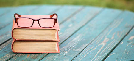 Story book, storytelling concept, old books and eyeglasses on a wooden background. Web banner with copy space.の写真素材