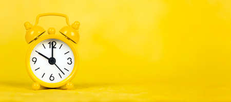 Alarm clock, watch on yellow background, save or manage time concept. Web banner with copy space.の写真素材