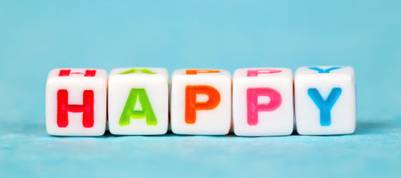 Happy, happiness concept, cubes with colorful letters on blue backgroundの写真素材