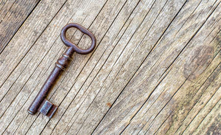 Escape room game concept, old vintage iron key on wooden background