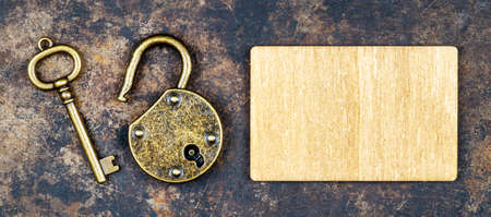 Escape room game concept, old vintage key and padlock on a rusty grunge background with blank. Web banner.の写真素材