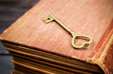 Golden heart shape key on an old book, love story, valentines day, self love conceptの写真素材
