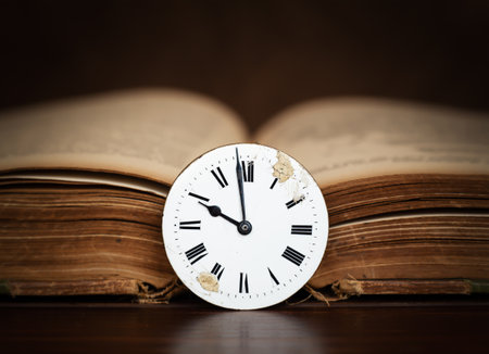Old book and antique clock face. Storytelling, storyteller, time background.の写真素材