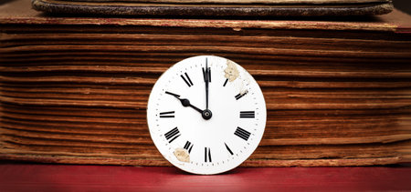 Old book and antique clock face. Storytelling, story teller, time background or banner.の写真素材