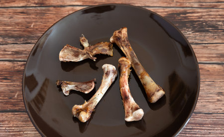 Chicken thigh bones on a plate. Food waste background.