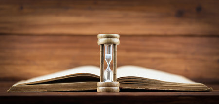 Hourglass with an old book. Time is passing, storytelling banner or background with copy space.の写真素材
