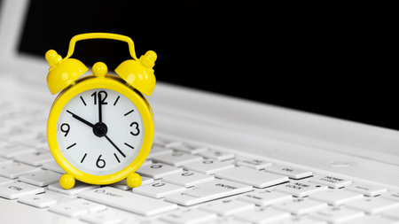 Alarm clock on a laptop keyboard, deadline concept. Background with copy space.の写真素材