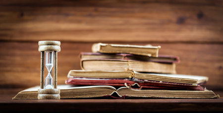 Hourglass with old books. Time is passing, storytelling concept. Banner or background with copy...