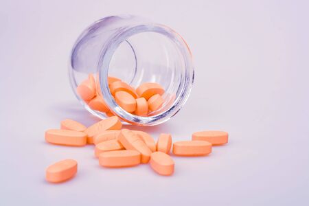 Pills pouring out of a prescription open bottle.