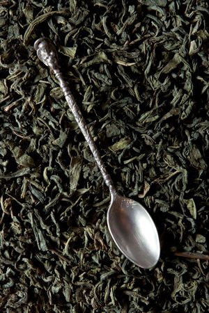 Green tea leaves and silver spoon