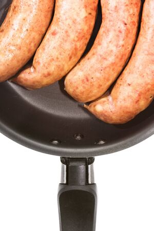 sausages in frying pan isolated on white backgroundの写真素材