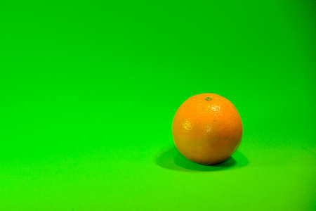 Strawberries and oranges on a green background.の写真素材