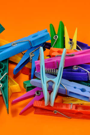 Set of colorful clothespins appearing one by one on an orange background.の写真素材