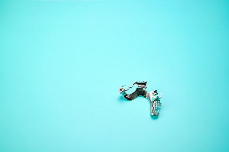 Metal removable dental prosthesis on a green work table.の写真素材