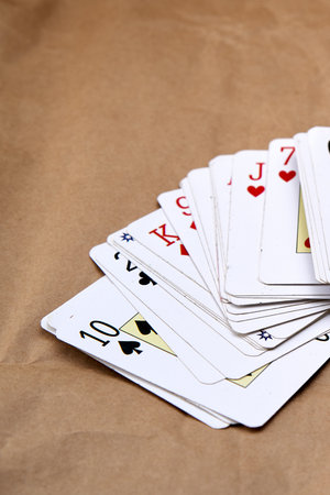 Shuffling of poker cards spread out on a cardboard-like surface.の写真素材