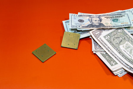 Microchips next to many dollars on an orange surface