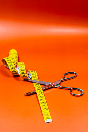 Measuring tape and sharpened scissors, placed on table