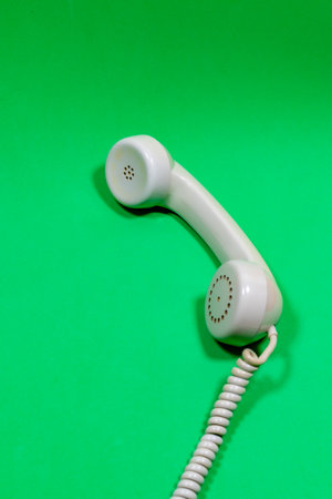 White handset of old telephone on a green surfaceの写真素材