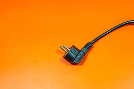 Black plug cable on an orange surface.の写真素材