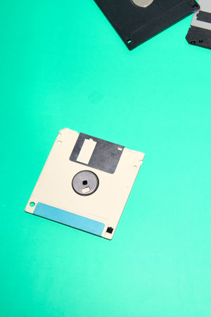 single floppy disk with a blue label sits on a turquoise background