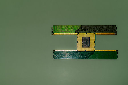 Close-up shot of a central processing unit (CPU) and RAM sticks on a green background, representing...