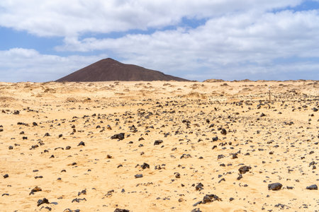 Dramatic landscape scene on La Graciosa, Canary Islands, with desert and a distant mountain.