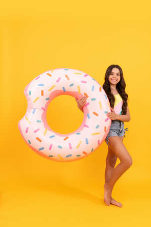 happy beach teen girl with donut inflatable ring for pool party fun on summer vacation, summertime.の写真素材