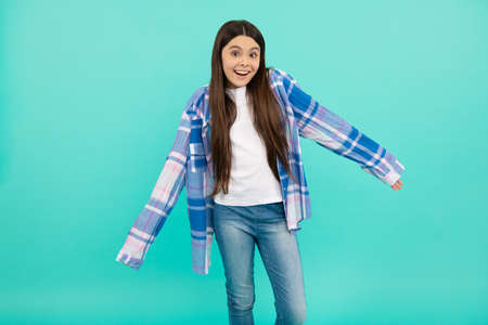 The shirt sleeves are too long. Teenage girl try on plaid shirt. Teenage fashionの写真素材