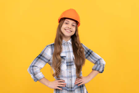 happy teen girl in helmet and checkered shirt, builder