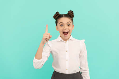 Everything begins with an idea. Happy child keep finger up blue background. Back to school ideaの写真素材