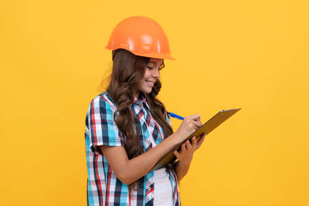 making notes. child in helmet read project. construction documents. signing a contract.の写真素材