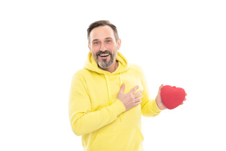 smiling senior guy hold present isolated on white. man in yellow hoody.の写真素材
