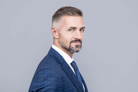 mature ambitious man businessman in businesslike suit has grizzled hair, success portrait