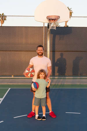 happy dad and son child play basketball with ball on playground, fatherhoodの写真素材